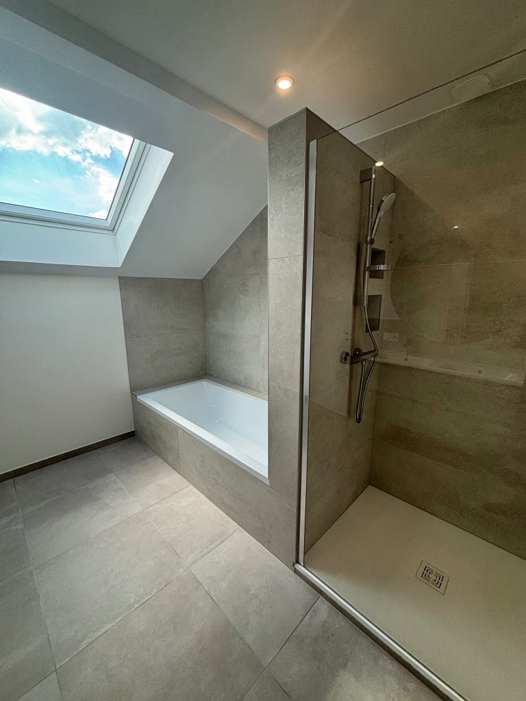 Salle de bain rénovée sous combles avec douche à l’italienne et baignoire, réalisée par EDIKS déco74